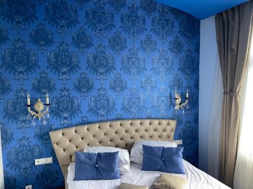 Casa Dunarea by Genco في بريدال: غرفة نوم زرقاء مع سرير بجدار ازرق
