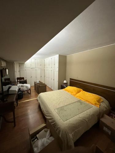 um quarto com uma cama grande e um cobertor amarelo em CASA BOMBAL em Mendoza