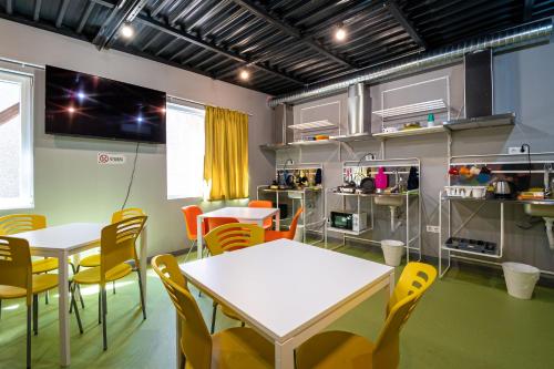 ein Zimmer mit 2 Tischen und Stühlen sowie einer Küche in der Unterkunft Green Cube Capsule Hostel in Sofia