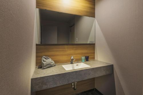 W łazience znajduje się umywalka i lustro. w obiekcie Takamiya Hotel Jurin w mieście Zaō Onsen
