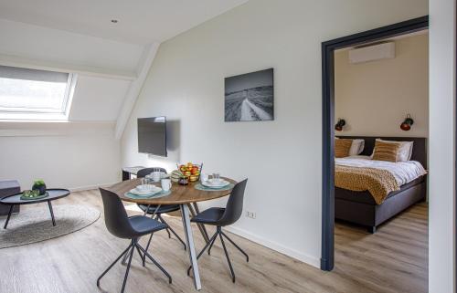 um quarto com uma cama, uma mesa e cadeiras em Barn24 - The Stable & The Loft em Roggel