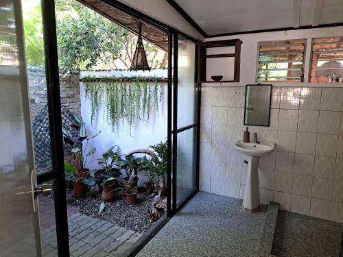 a bathroom with a sink and a toilet with plants at Private 1-BR Bungalow #3 in Moalboal