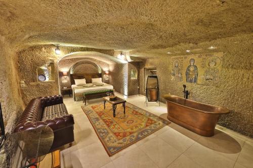 Habitación con cama y sofá en una cueva en Divan Cave House en Göreme