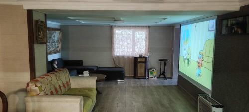 a living room with a large projection screen at The Friends in Kutaisi