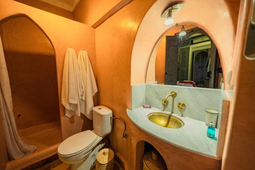 a bathroom with a toilet and a sink with a mirror at Riad Azawan in Marrakesh