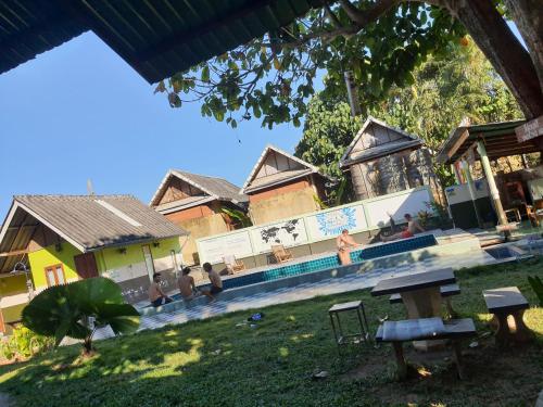 un groupe de personnes assises autour d'un bâtiment avec piscine dans l'établissement Peace of Love Pai, à Pai