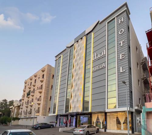 a large building with cars parked in a parking lot at Abela Al Hamra - Palestine Street in Jeddah