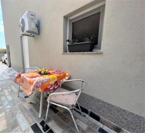 a table and chairs on a patio with a window at Melek in Medulin