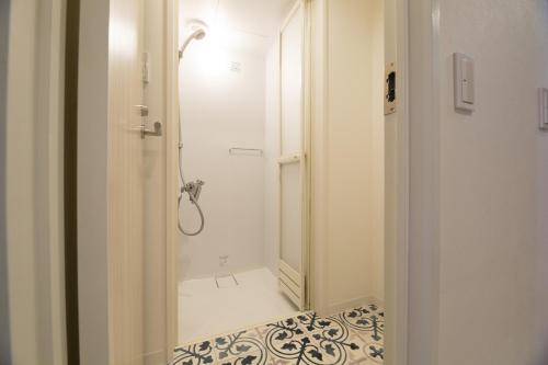 a white bathroom with a shower and a toilet at あやきちゲストハウス in Daikōchō