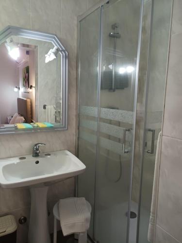 bagno con lavandino e doccia in vetro di Hotel Branco I a Praia da Vitória