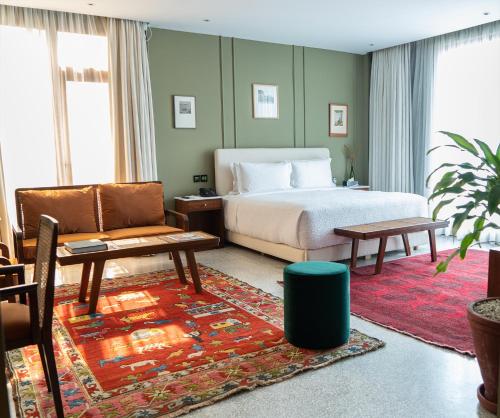 una camera con letto, divano e sedia di The Fred Hotel a Lahore