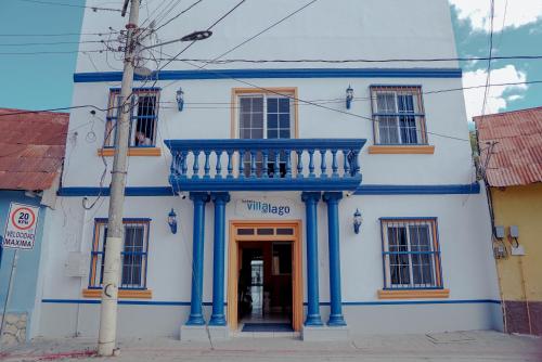 a blue and white building with a balcony at Hotel Villa del Lago in Flores