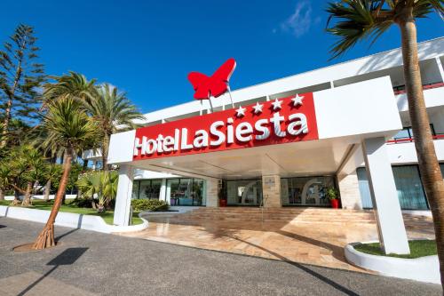 un hotel la casita con un pájaro rojo en la parte superior en Alexandre Hotel La Siesta, en Playa de las Américas