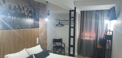 uma sala com um quarto com uma cama e uma escada em Hostal Fronton em Alcobendas