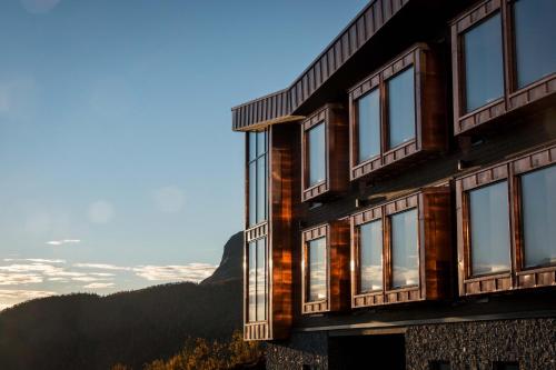 um edifício com janelas e montanhas ao fundo em Skarsnuten Mountain Resort & SPA em Hemsedal