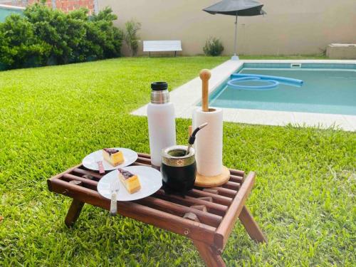 uma mesa de piquenique com comida ao lado de uma piscina em Chito House em Buenos Aires