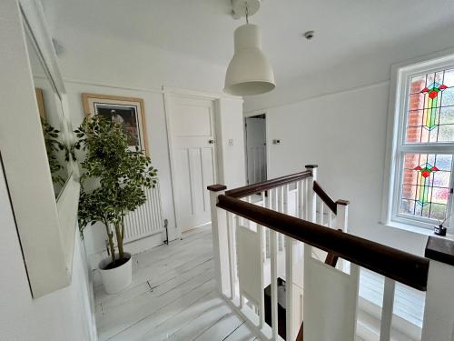 un couloir blanc avec un escalier et une fenêtre dans l'établissement Palm - Bournemouth, à Bournemouth