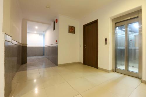 an empty hallway with a door and a tile floor at Airport Hotel Chanakya in New Delhi