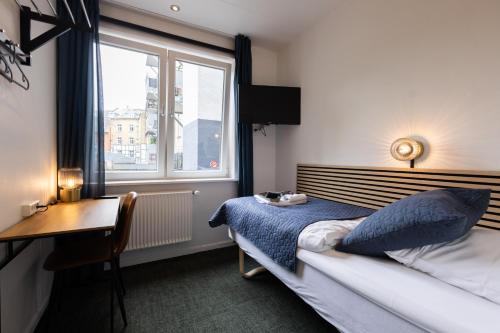 um quarto com uma cama, uma secretária e uma janela em Milling Hotel Mini 11 em Odense