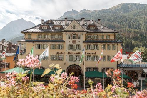 un gran edificio con banderas delante en Hotel Dolomiti Schloss en Canazei