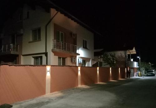 uma cerca em frente a um edifício à noite em ViBo Guesthouse em Sapareva Banya