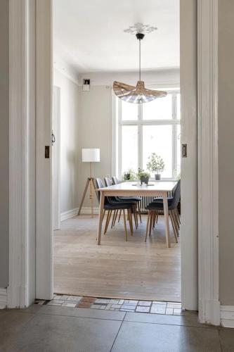 a dining room with a table and chairs and a chandelier at Olympia! Premium apartment Beautiful and Central in Helsingborg