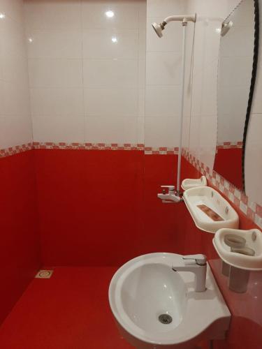 uma casa de banho vermelha com um WC e um lavatório em Madina Hotel em Faisalabad