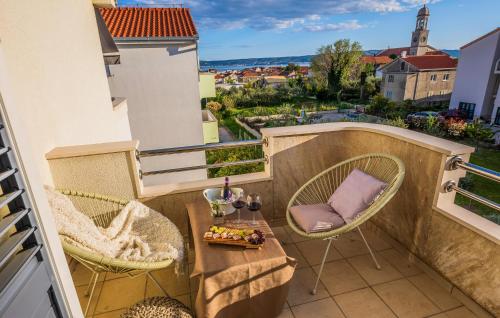 een balkon met 2 stoelen en een tafel en uitzicht bij Cozy Apartment In Kastel Stari With Kitchen in Kaštela