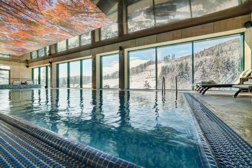 - une piscine dans un bâtiment avec vue sur la montagne dans l'établissement Hotel Pegaz, à Krynica-Zdrój