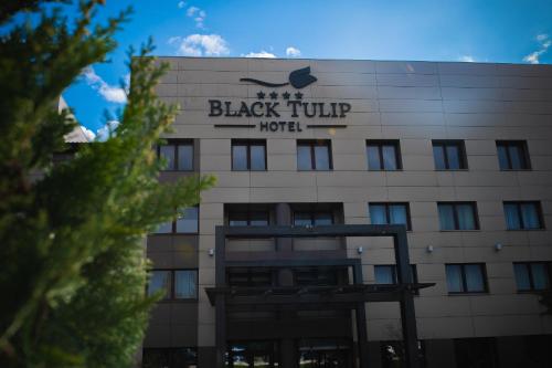 un bâtiment avec un panneau indiquant l'hôtel de tulipes noirs dans l'établissement Black Tulip Hotel, à Dej