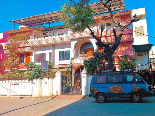 una furgoneta azul estacionada frente a un edificio en Jwala Niketan JAIPUR, en Jaipur