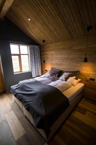 1 dormitorio con 2 camas en una pared de madera en Fjalladýrð Hotel en Modrudalur