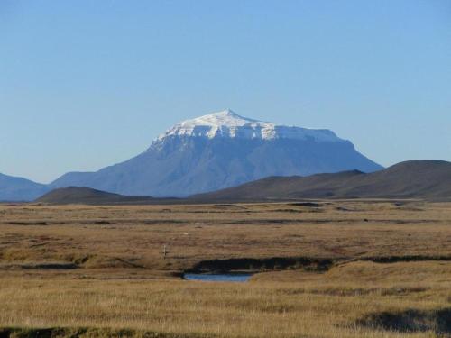 una montaña cubierta de nieve en medio de un campo en Fjalladýrð Hotel en Modrudalur