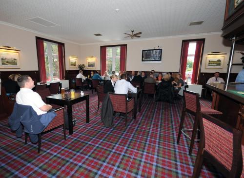 un groupe de personnes assises à table dans un restaurant dans l'établissement Pinehurst Lodge Hotel - Aberdeen, à Dyce