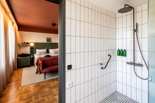 uma casa de banho com chuveiro e um quarto em Hotel Fratelli em Karlstad