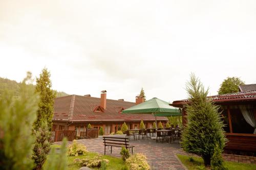 eine Terrasse mit einem Tisch und einem grünen Sonnenschirm in der Unterkunft Chalet Filvarok in Slawske