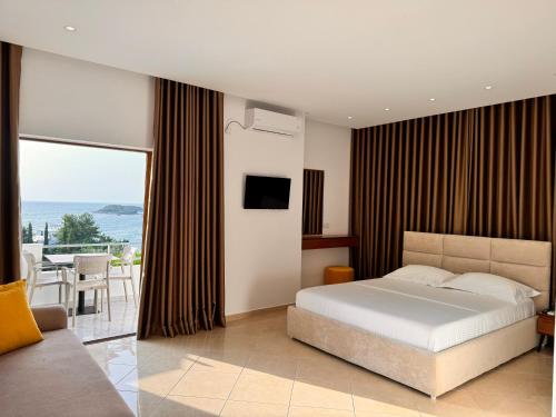 1 dormitorio con cama y vistas al océano en Dine Apartments, en Ksamil