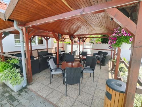 a patio with tables and chairs under a wooden pergola at Hotel Orlan in Bratislava