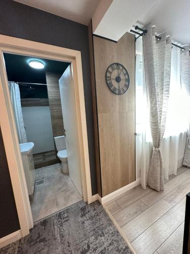 a bathroom with a toilet and a clock on the wall at Luxury Studio in Iaşi