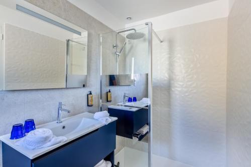 a bathroom with a sink and a shower at Hotel Espadon bleu in Le Lavandou