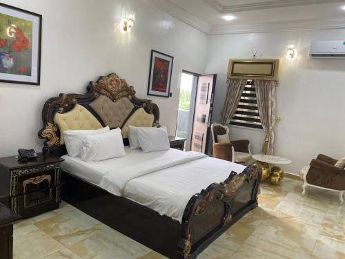 1 dormitorio con 1 cama grande y una escalera en Kawruky Hotel Benin en Benin City