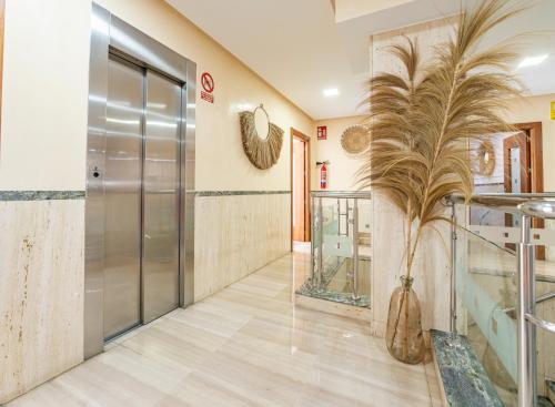 een lobby met een glazen deur en een plant in een vaas bij Hotel Las Américas in Málaga