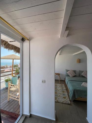 1 dormitorio con 1 cama y balcón con vistas al océano en Surf HouseMaroc en Esauira