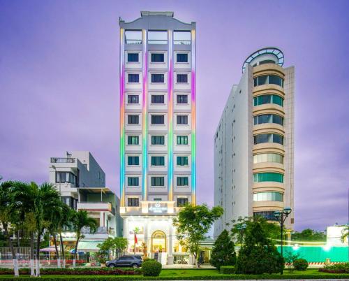 ダナンにあるLe Indochina Hotel & Beach Da Nang Cityのヤシの木が茂る都市の高層ビル2棟