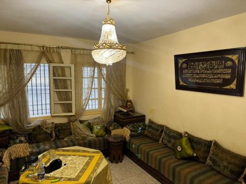 a living room with a couch and a chandelier at appart charaf in Taza