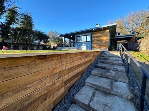 a home with a wooden retaining wall and stairs at Sky Hotel Boutique in Osorno