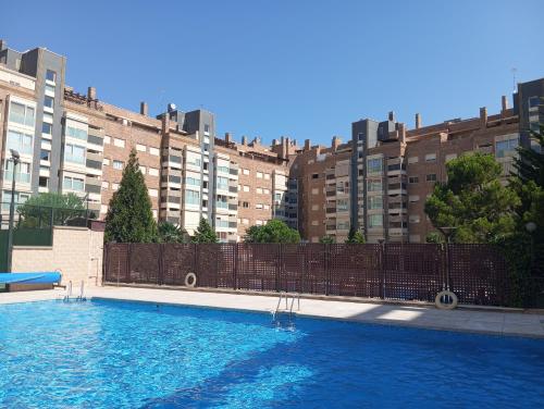 una grande piscina di fronte a un edificio di Madrid Las Tablas apartments a Madrid