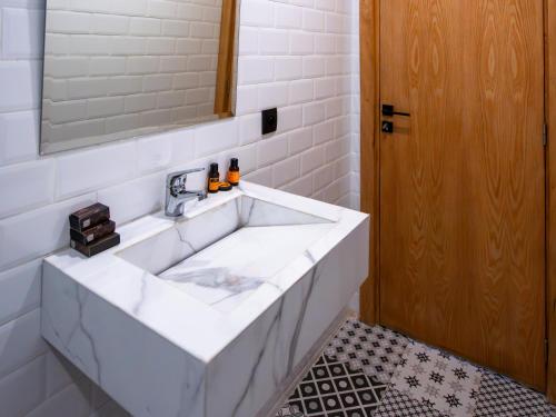 a white sink in a bathroom with a mirror at Unico Hotel Maarif in Casablanca