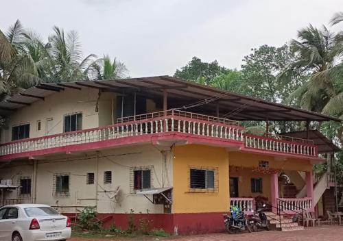 a house with a car parked in front of it at Sawant Homestay Ganpatipule in Ganpatipule