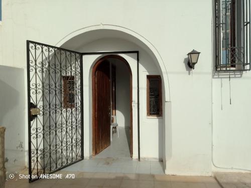 an entrance to a white building with a wooden door at La rose 1 in Mezraya